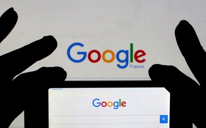 A woman holds her smart phone, which displays the Google home page, in this picture illustration taken February 24, 2016. REUTERS/Eric Gaillard/Illustration/File Photo