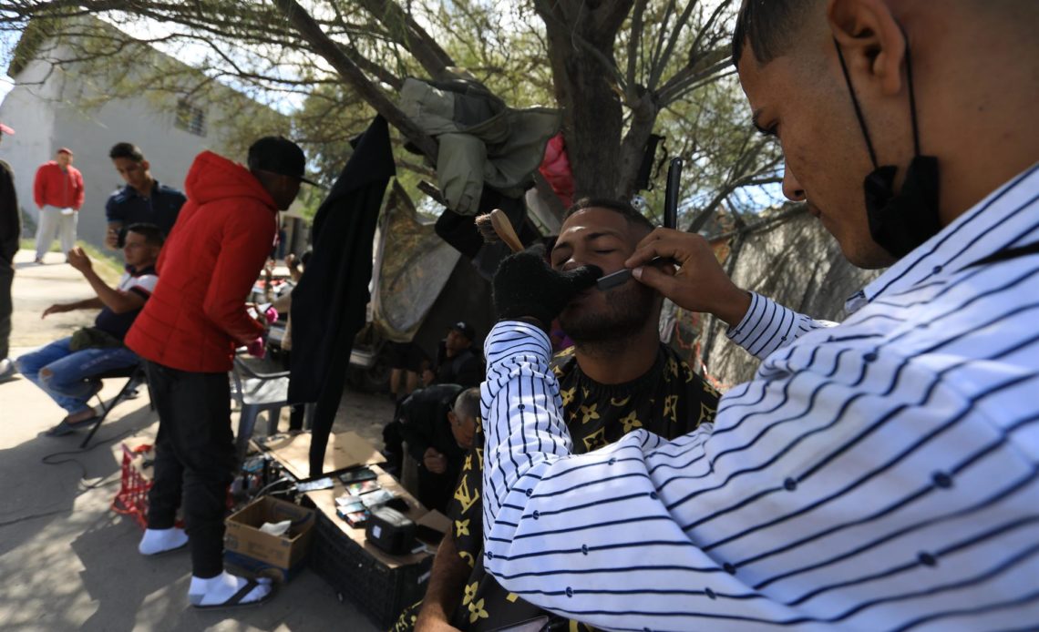 Venezolanos varados en la frontera de México subsisten como barberos