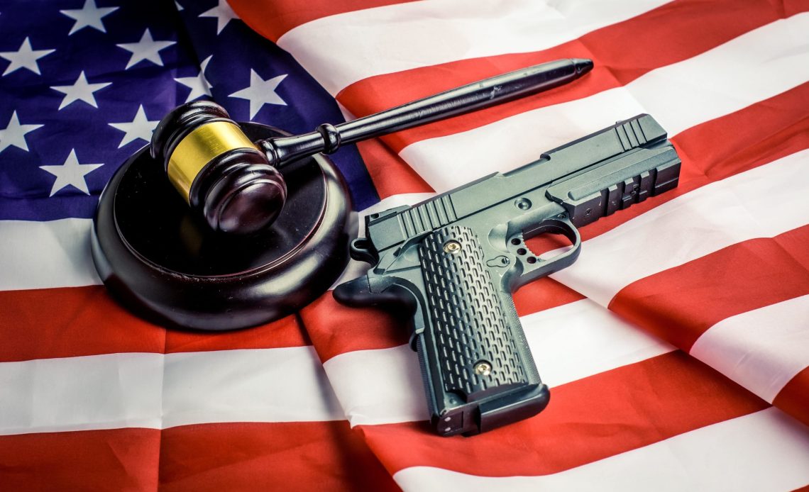 Arma de fuego encima de bandera de EEUU