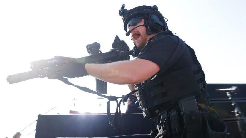 Un agente de las fuerzas de seguridad en alerta tras los disparos sobre el escenario en el mitin de Donald Trump.