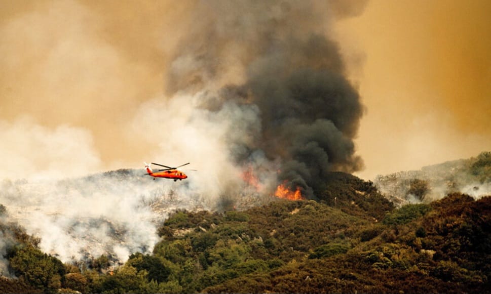 Atenas (EFE).- Cientos de bomberos luchan este lunes por segundo día consecutivo contra un gran incendio forestal que, atizado por fuertes vientos, ha llegado a las puertas de Atenas y ha forzado a las autoridades a evacuar a decenas de miles de personas, dijo a EFE una portavoz de los Bomberos. Unos 700 bomberos con 183 camiones, 17 aviones y 15 helicópteros cisterna operan en la zona para contener las llamas, que se extienden en un frente de unos 30 kilómetros, según ha informado el ministro de Protección Civil de Grecia, Vasilis Kikilias, en comparecencia ante la prensa. Se trata de un fuego extremadamente peligroso, contra el cual hemos luchado durante más de 20 horas en condiciones dramáticas”, señaló Kikilias. Un bombero trabaja en la extinción del incendio forestal declarado en Penteli, al noreste de Ática, Grecia Un bombero trabaja en la extinción del incendio forestal declarado en Penteli, al noreste de Ática, Grecia, este 12 de agosto. EFE/EPA/EFE/EPA/Alexandros Beltes El viento y la orografía complican el control de las llamas Además, explicó que la combinación de fuertes vientos, la prolongada sequía y “una morfología de terreno difícil e inaccesible en un denso bosque” dificultan las tareas de extinción. El fuego se declaró el domingo cerca del pueblo de Varnava, a unos 40 kilómetros al norte de Atenas, y se propagó rápidamente durante la noche hacia el sur hasta llegar cerca de la localidad de Penteli, a unos 15 kilómetros al norte de la capital y al límite del tejido urbano de la ciudad. “Los vientos son muy intensos y no nos está ayudando tampoco la morfología del terreno ni la vegetación que son principalmente pinos y acebos que se queman rápidamente”, dijo a EFE la portavoz. Un humo espeso cubre la carretera nacional que conduce a Atenas debido a un incendio forestal declarado en una zona agrícola en Varnavas, cerca de la capital helena. EFE/EPA/Alexandros Beltes Un bombero ha sido trasladado a un hospital militar cercano con quemaduras de segundo grado en las manos y en los pies, mientras que cinco ciudadanos han sido trasladados a otro hospital con problemas respiratorios. Más de 35.000 personas desalojadas Las autoridades ordenaron en la madrugada de este lunes la evacuación de ocho localidades al sur del monte Penteli, que se sumaron a las más de 15 ya desalojadas el domingo más al norte. En total, se calcula que más de 35.000 personas han tenido que abandonar sus hogares, aunque este número podría ser mucho mayor ya que en esta zona se encuentran también muchas residencias de veraneo de ciudadanos atenienses. También tuvieron que ser evacuados dos hospitales, uno de niños y otro militar, así como dos monasterios. Los principales frentes se sitúan actualmente cerca del pueblo de Gramatikó, unos 40 kilómetros al norte de Atenas, y del pueblo costero de Nea Makri y la localidad de Dióni al este de la capital. Las llamas han calcinado varias casas y todavía amenazan zonas pobladas, mientras que las autoridades de algunos pueblos denuncian la falta de medios aéreos y terrestres. Un bombero inspecciona los daños causado por el fuego en una vivienda en Dionysos, al norte de Ática, Grecia, este 12 de agosto. EFE/EPA/George Vitsaras “El fuego ha alcanzado la primera casa, las llamas están a unos 5 metros del pueblo y en este momento operan medios aéreos y un camión de los bomberos. Necesitamos refuerzos terrestres”, dijo a la emisora pública ERT el presidente de la comunidad del pueblo de Gramatikó, Spyros Zagaris. El humo del incendio ha llegado hasta la ciudad de Kalamata, en la Península del Peloponeso, situada a unos 200 kilómetros al suroeste de Atenas, según los medios locales. Los meteorólogos vaticinan que la temperatura alcanzará un máximo de 36 grados en la región capitalina de Ática, y que persistirán los fuertes vientos.