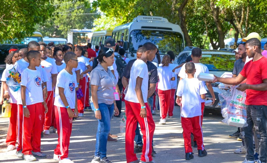 Comedores Económicos repartiendo snacks a los jóvenes asistentes